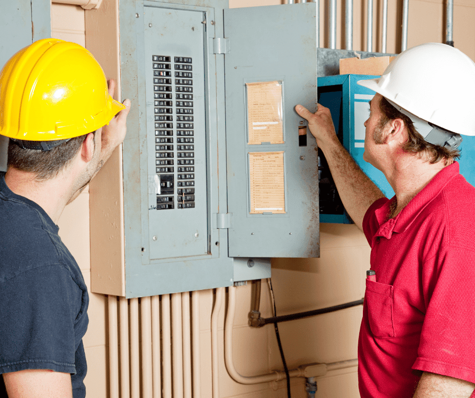 Two Laswell Electric electricians inspecting an electrical panel, ensuring safe, code-compliant service for homes and businesses in Kentucky and Indiana.