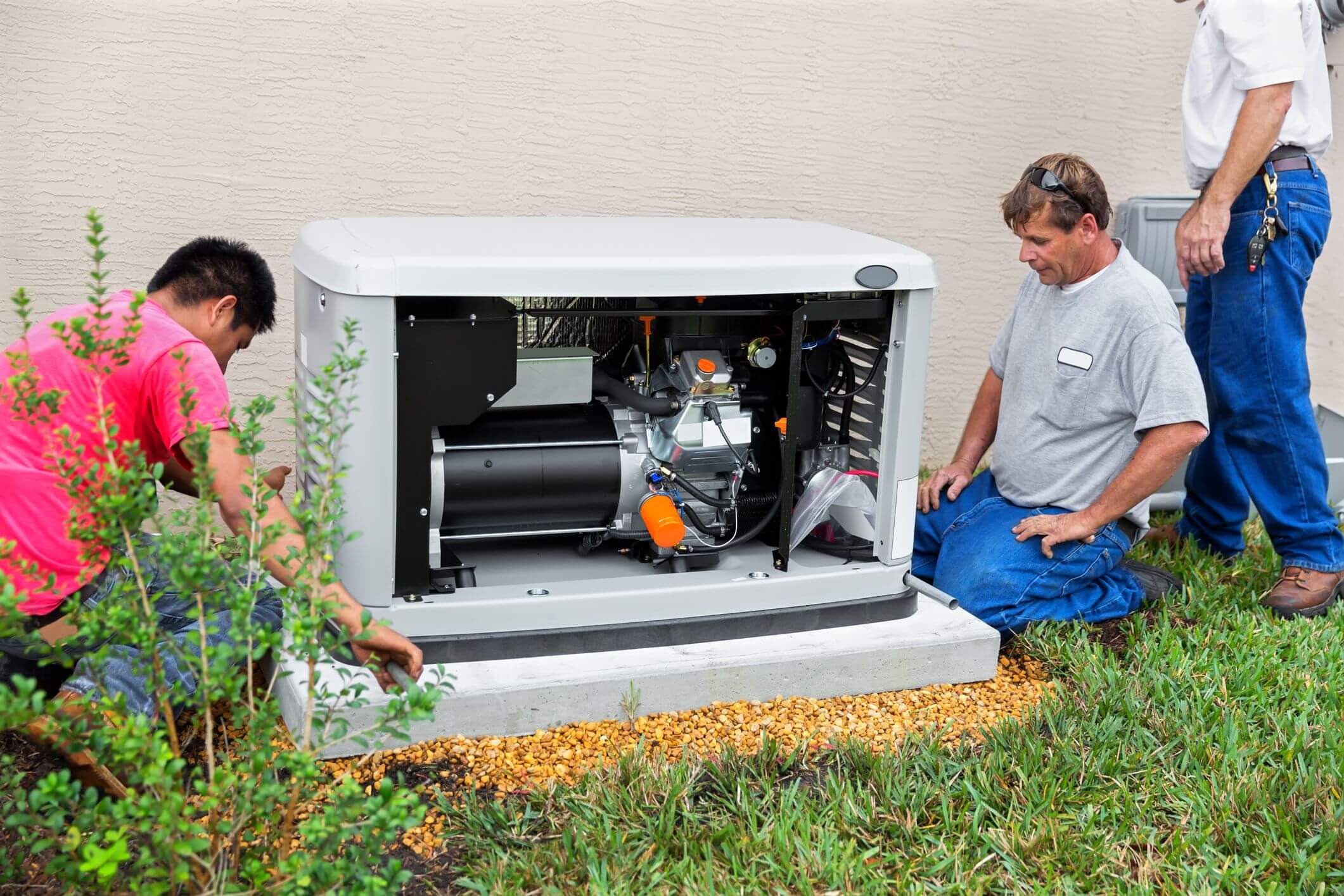 Picture of three electricians installing a home backup generator