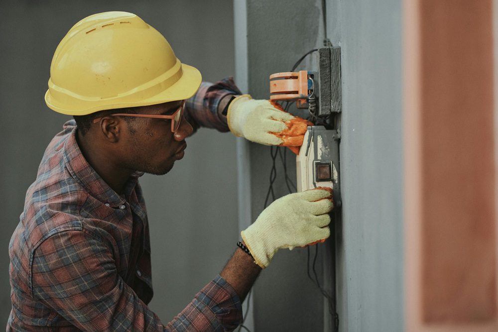 Picture by Pexels.com An electrician working on an electrical panel wearing safety gear for Laswell Electric, the best electric company in Louisville and Indiana.