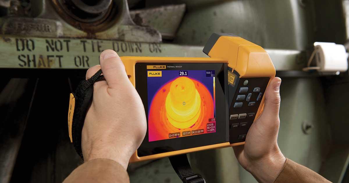 Laswell Electric technician using an infrared thermography camera to detect electrical hotspots and prevent system failures in commercial wiring.