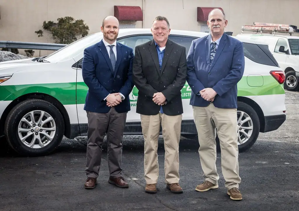 Justin Laswell, Sean Shelton and Steven Laswell standing in front of a Laswell Electric work truck.