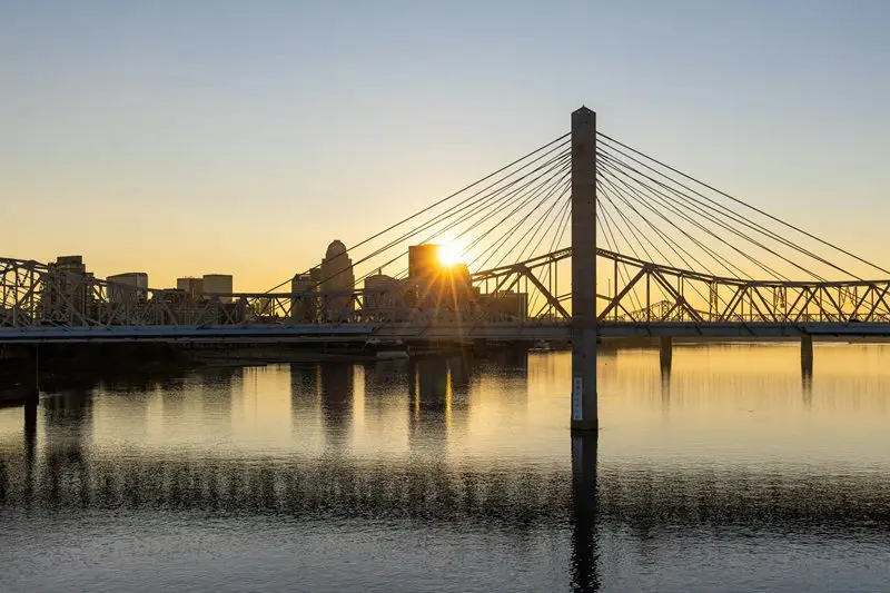 Sunrise over the Louisville skyline and cable-stayed bridge, symbolizing Laswell Electric’s commercial and industrial electrical services across Kentucky and Indiana.