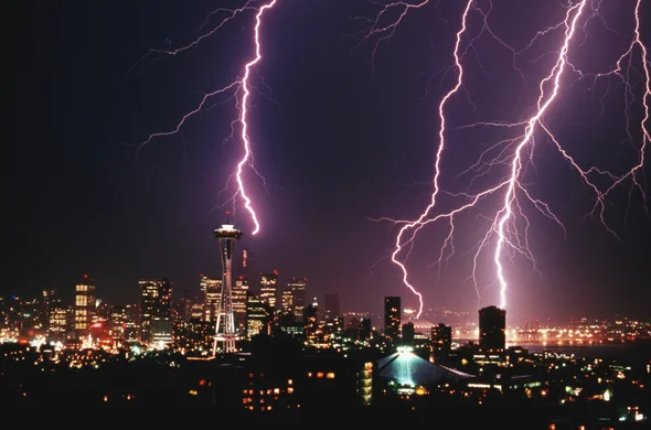 Lightning striking a city, emphasizing the importance of surge protection and electrical safety services from Laswell Electric in Kentucky and Indiana.
