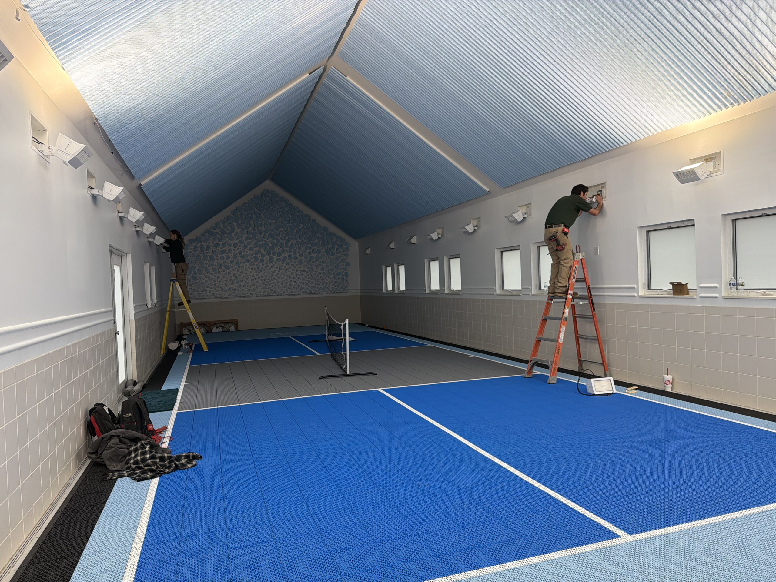 Laswell Electric electricians installing LED lighting for an indoor pickleball court in Jeffersonville, Indiana