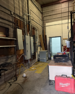 Electrical panels installed by Laswell Electric at Midwest Environmental Services, featuring company branding and organized wiring
